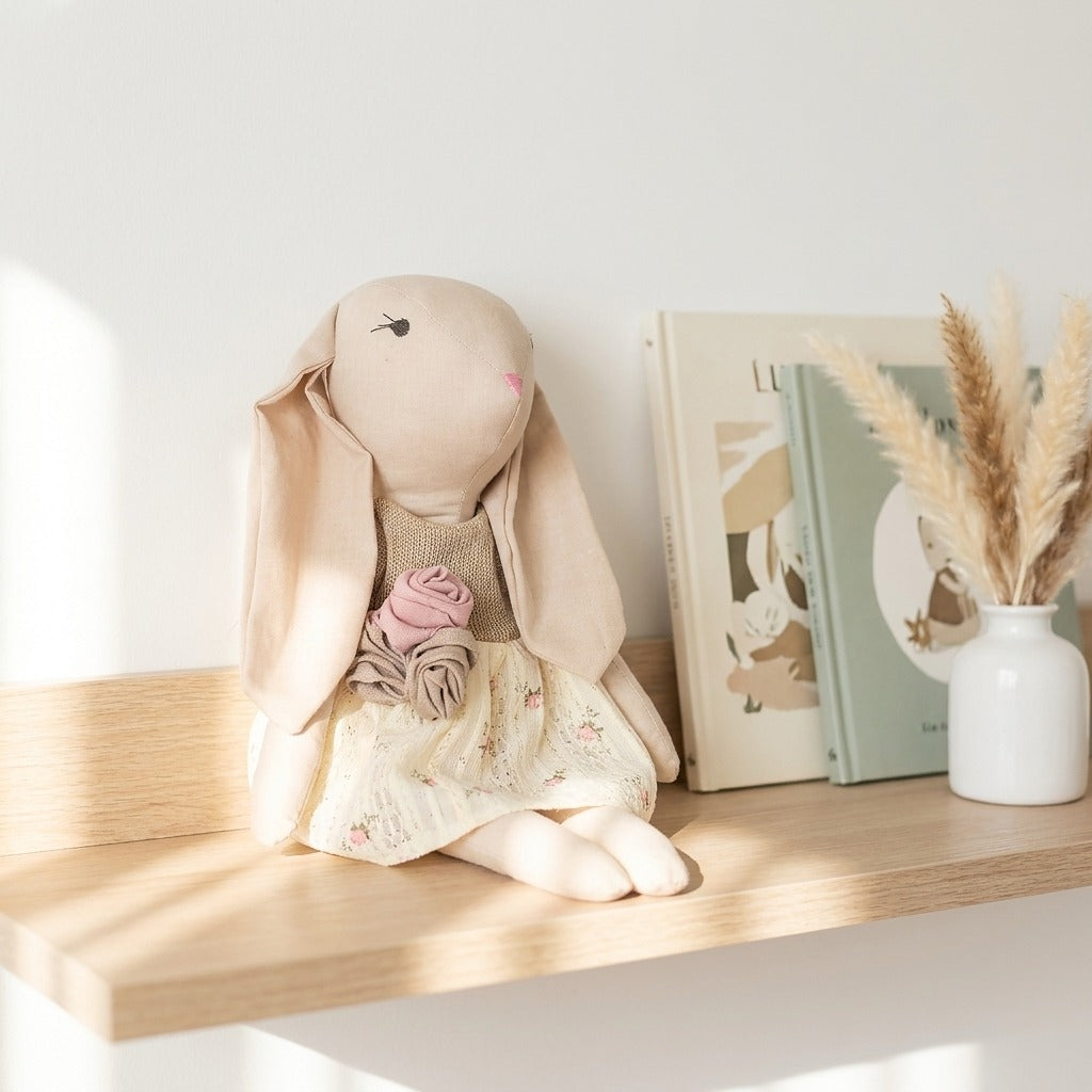 Conejita artesanal con vestido floral sobre repisa de madera en habitación nórdica